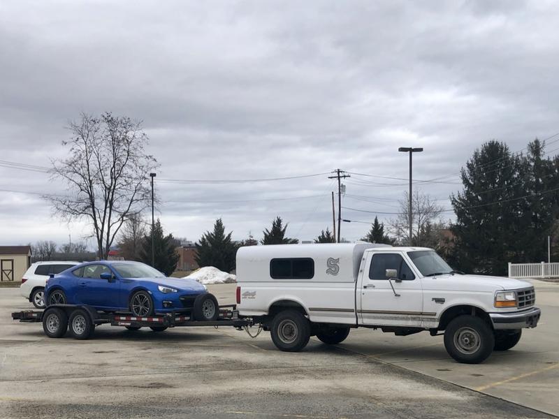 Old F250 towing a trailer with a Subaru BRZ on it